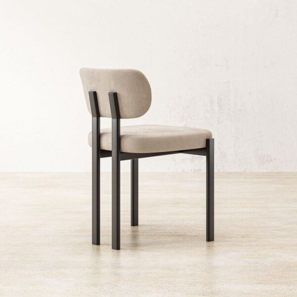 Rear-side view of the Solene dining chair highlighting the unique backrest design, which is slightly curved for better lumbar support. The chair's frame is made of high-quality black steel, designed to complement the soft beige upholstery. The simple yet elegant design makes it a versatile addition to various dining settings