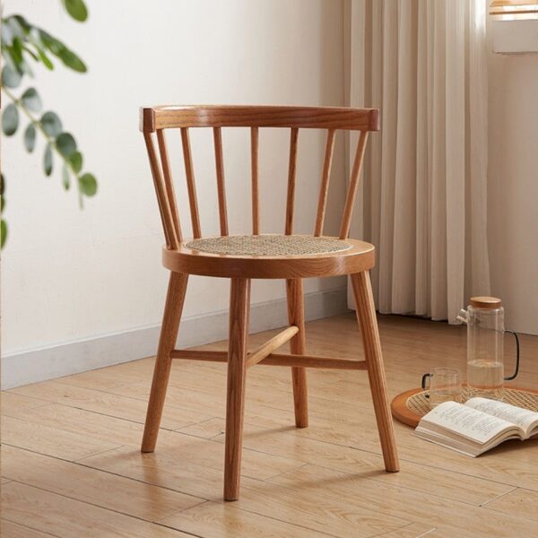 Side view of Eberly Wood Dining Chair in a natural setting, highlighting its sturdy beech wood legs and rattan seat.