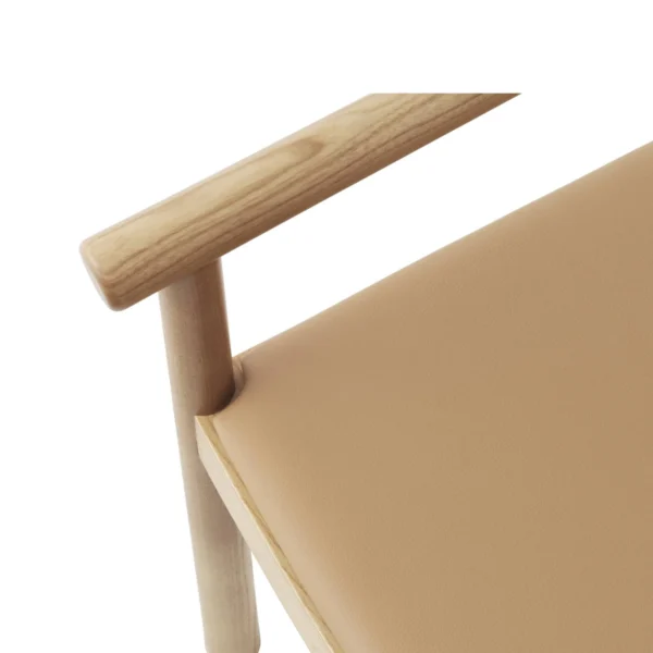 op-down view showing the armrest and seat of tobi dining wooden chair, featuring a light natural wood finish and beige upholstery