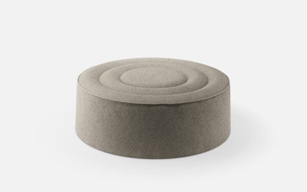 Round pouf in light gray fabric, featuring a minimalist design with concentric circular stitching on the top surface