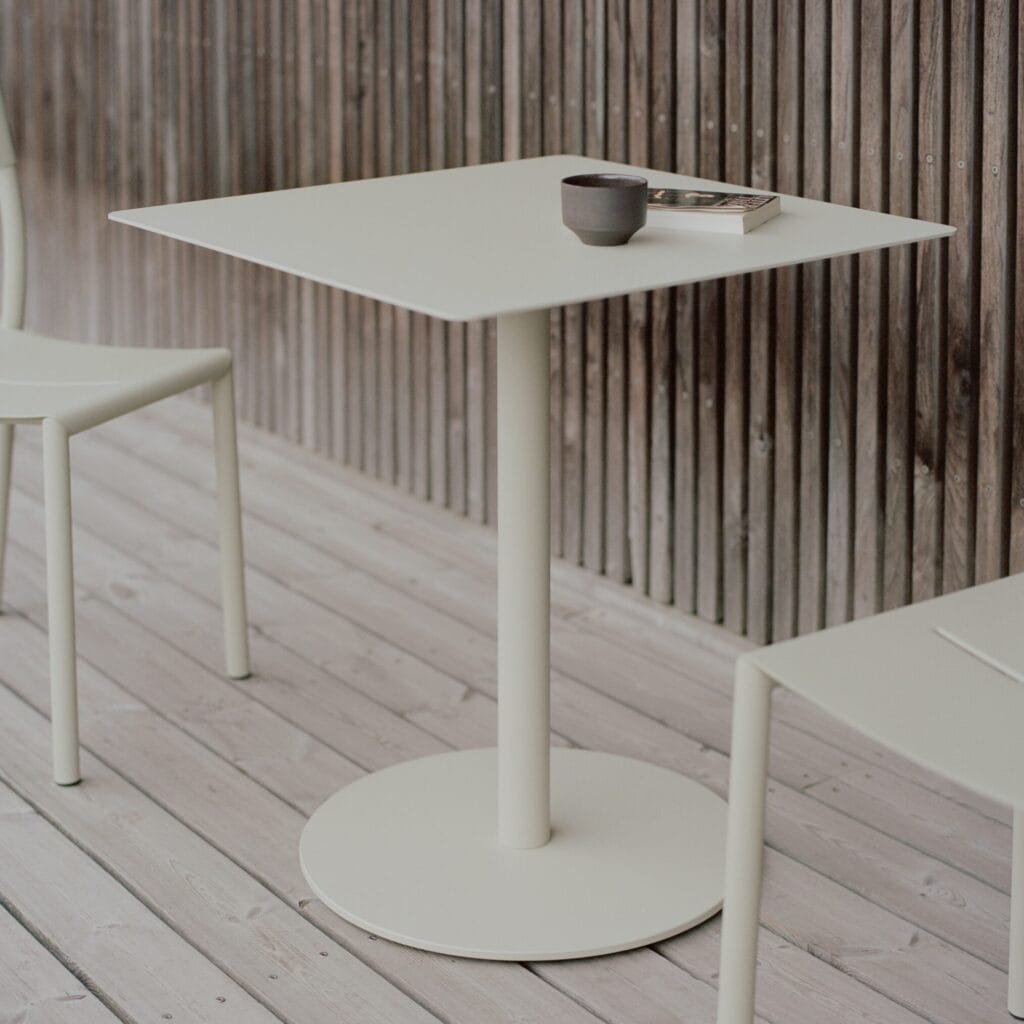 Outdoor square bistro table, with a single pipe column that sits on a round steel base on the floor , powdercoated in greyish green
