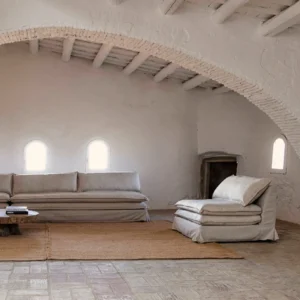 Lynn Lounge Chair and sofa in a rustic living room with arched ceiling