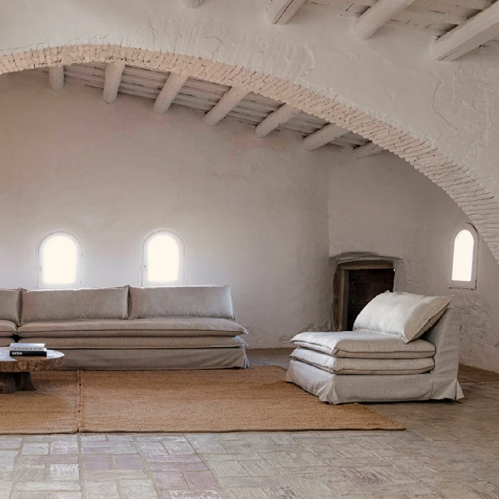 Lynn Lounge Chair and sofa in a rustic living room with arched ceiling