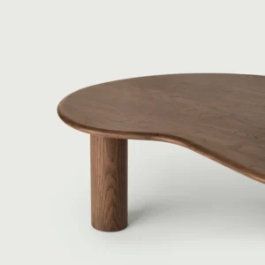 Close up of a single cylindrical leg and the curve of the tabletop of olly coffee table