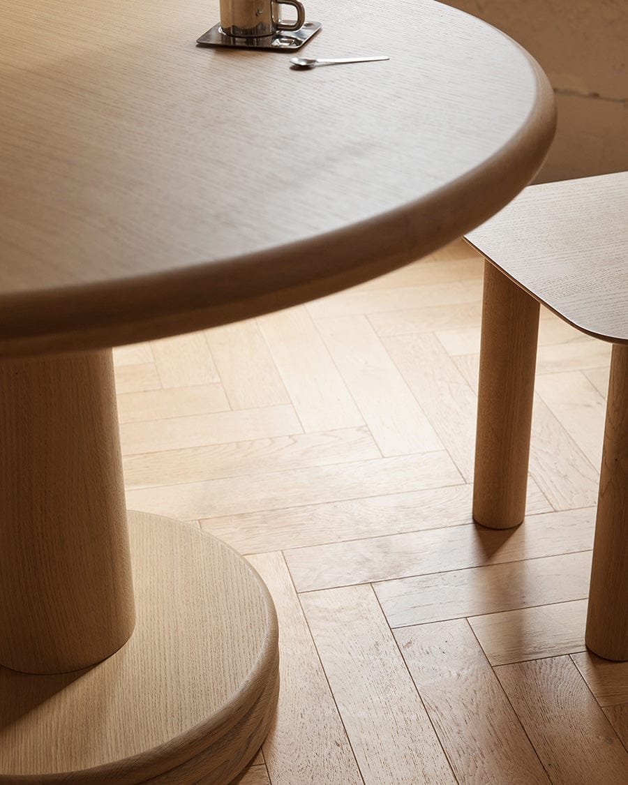 Top view of allure dining table showing the french oak top veneer and the solid wood base, aesthetic image shown in a beautiful interior